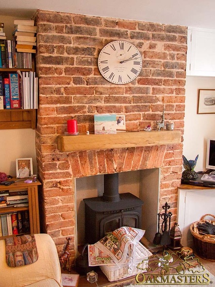 Modern oak beam inset in a brick fireplace