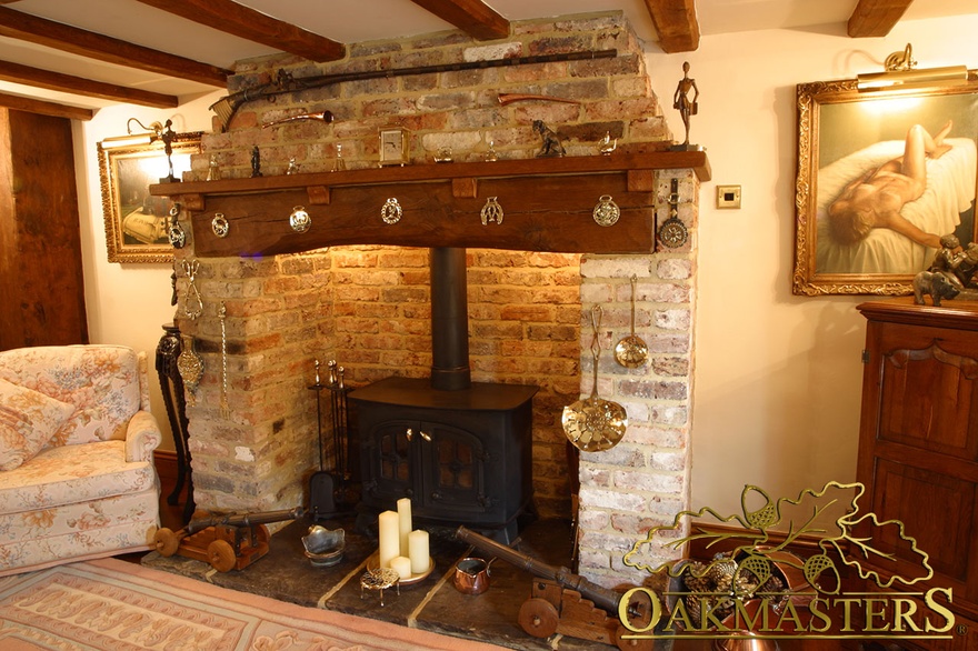 Large oak fireplace beam complimented by a small mantle shelf with traditionally designed oak corbels