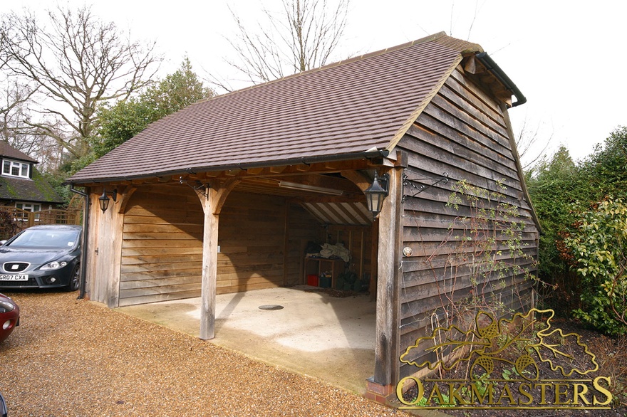 Two bay open oak framed garage with barn hip and cat slide roof