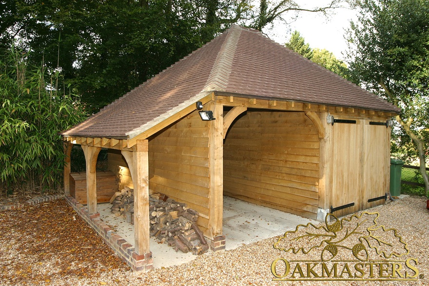 Two bay semi closed oak framed garage with log store