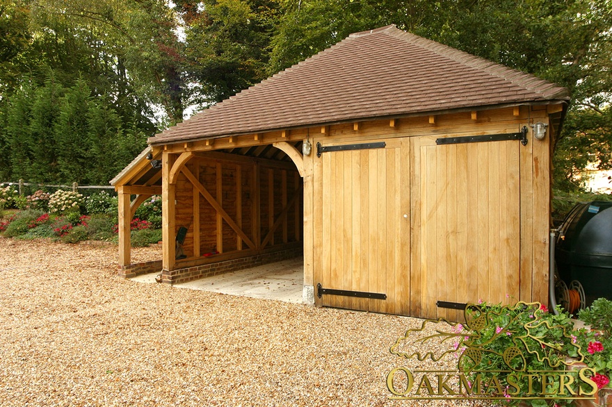 Two bay oak framed garage with hipped roof and oak garage doors