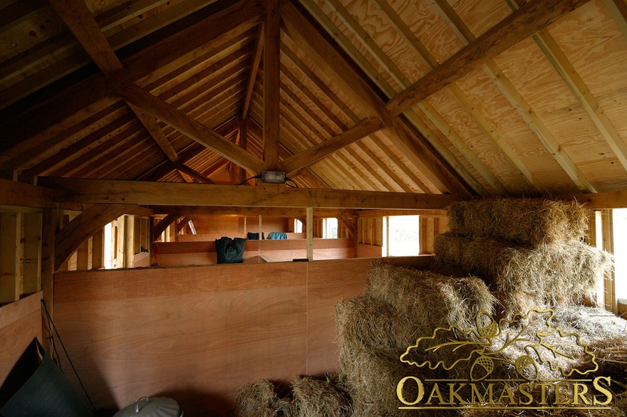 detail of king post truss inside an oak framed stable complex