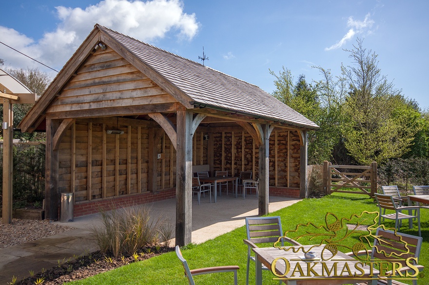 Oak posts and curved braces on detached summer garden shelter and entertaining space