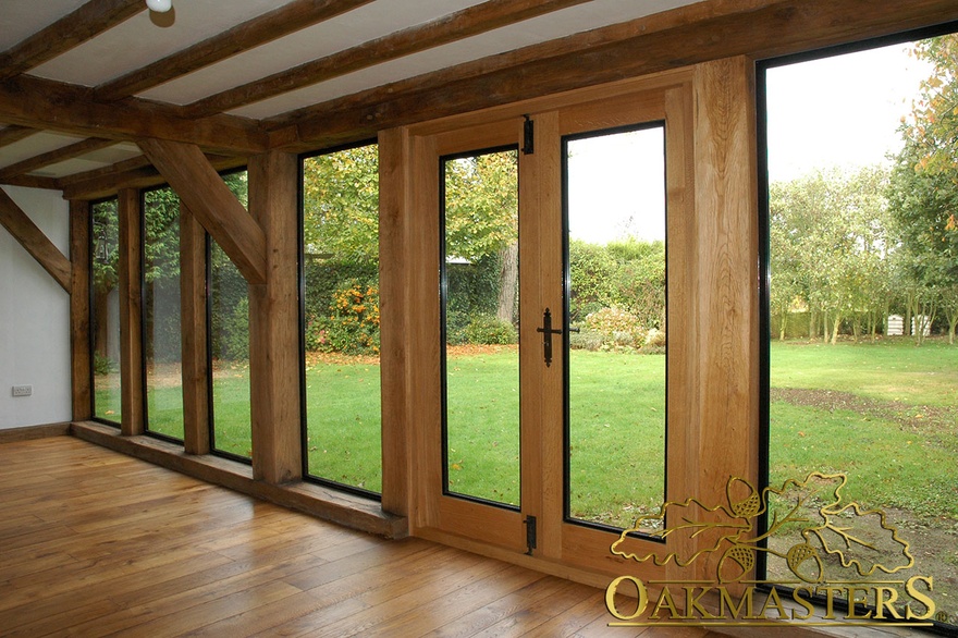 Straight oak columns frame glazed window and patio door of extension room