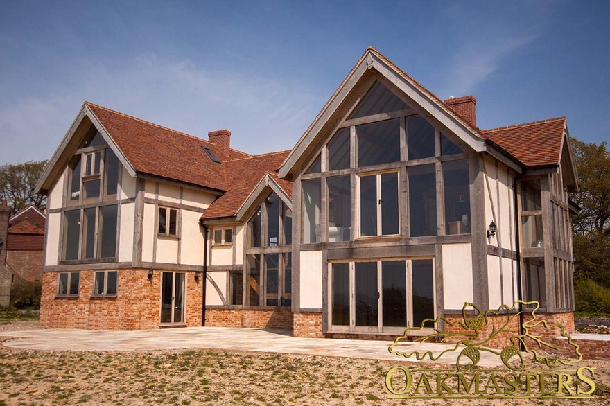 Rear exterior of large country house with oak frame and glazed gables