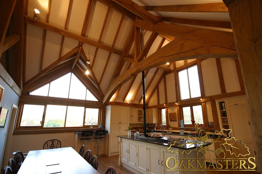 Inside glazed gable and exposed ceiling rafters in large kitchen dining room of listed house extension