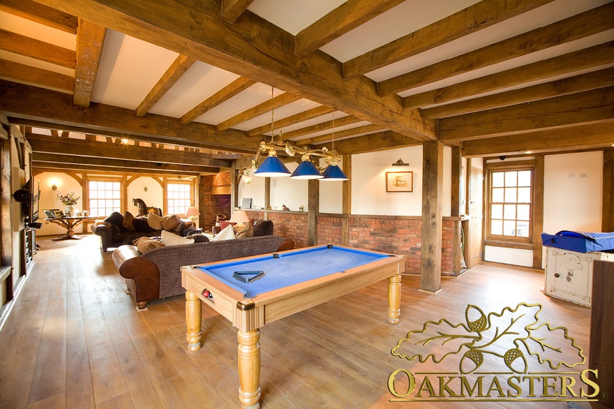 Straight oak columns and ceiling beams in sitting and games room in Isle of Man home