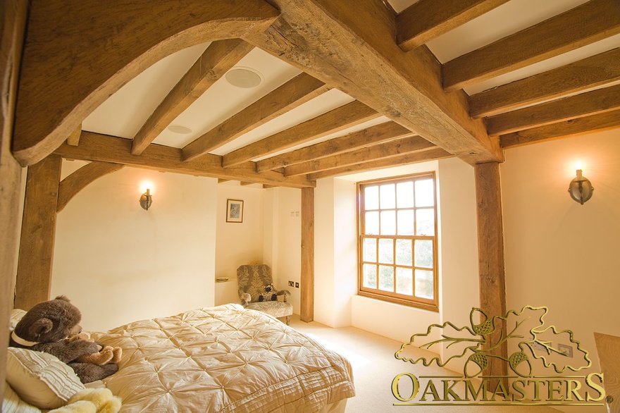 Curved manx oak braces and ceiling beams in bedroom