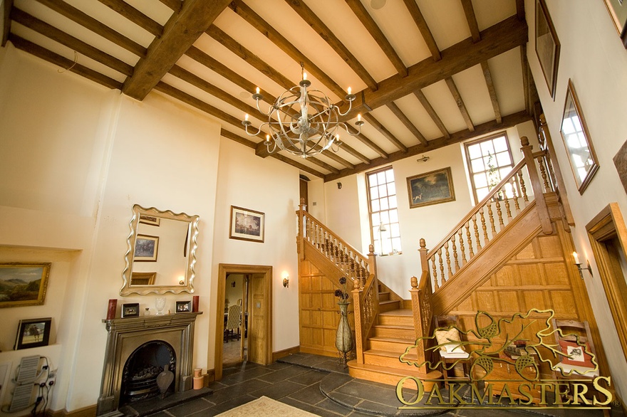 Entrance hall of Manx oak and stone house with butterfly staircase and exposed ceiling rafters