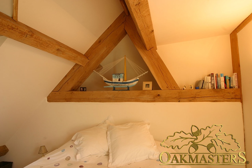 Decorative display shelf created from exposed beam in country house loft bedroom