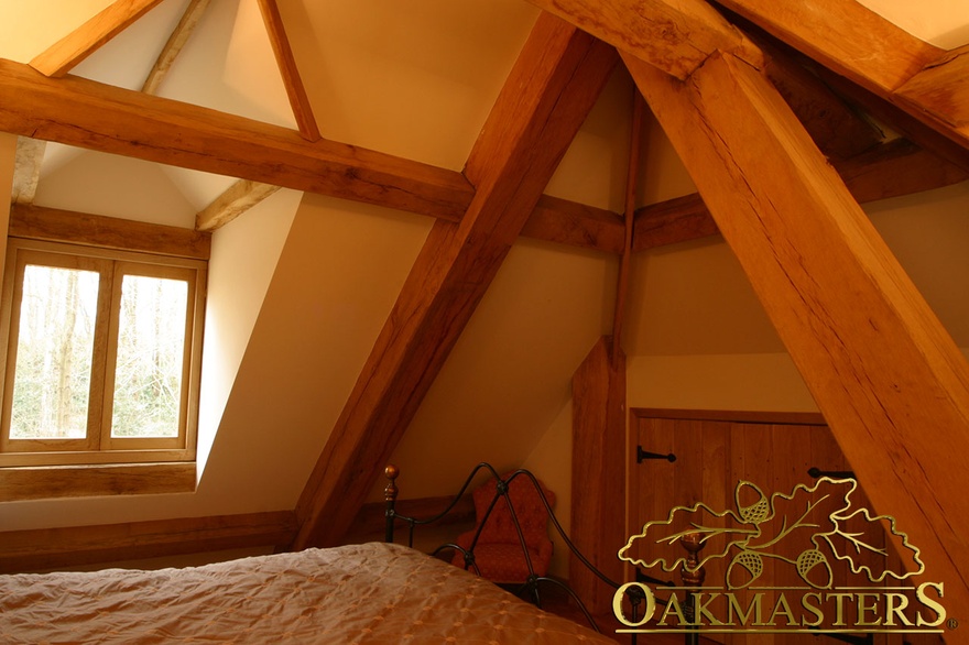 Bedroom in roof with exposed oak frame and integrated storage 