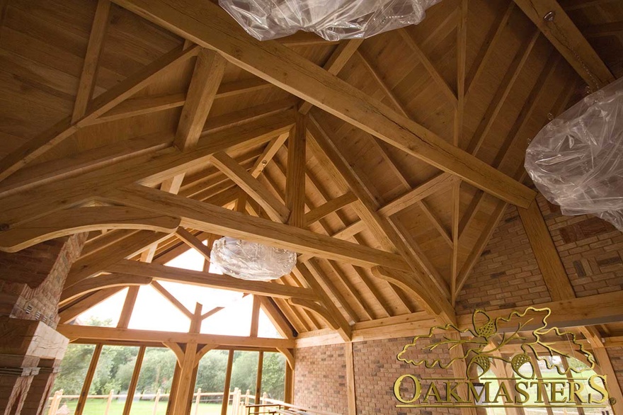 Extensive exposed oak ceiling with raised tie trusses and glazed gable end in country house