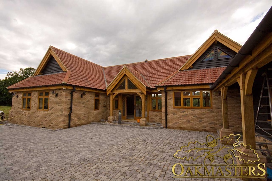 Front exterior of single storey country residence with oak frame windows and porch