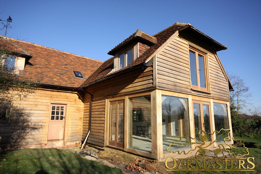 L shaped country house with oak featheredge cladding and oak framed glazing