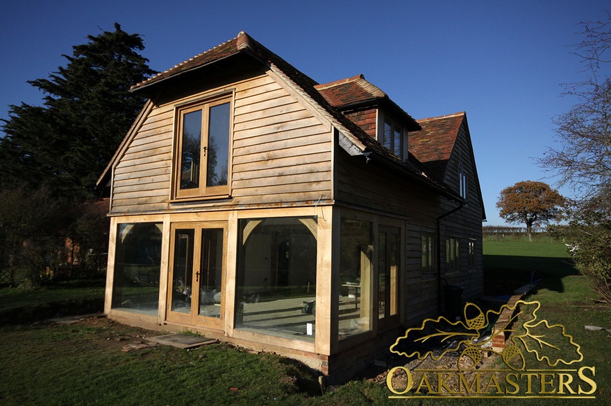 Exterior of small country house with oak cladding and partial glazing