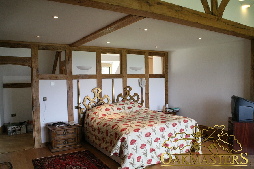 Exposed oak frame partition wall in unusual country house bedroom
