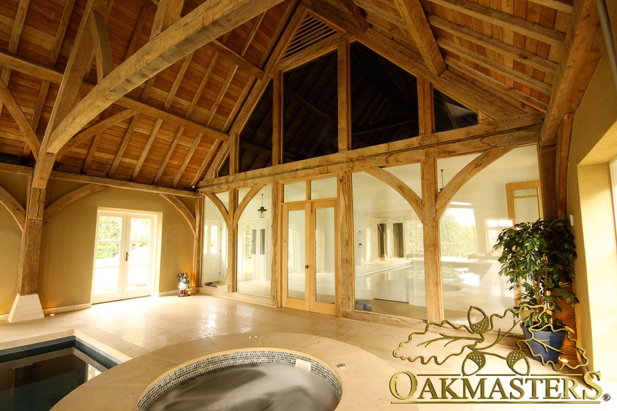Internal oak frame glazing in large pool building with oak timber open roof