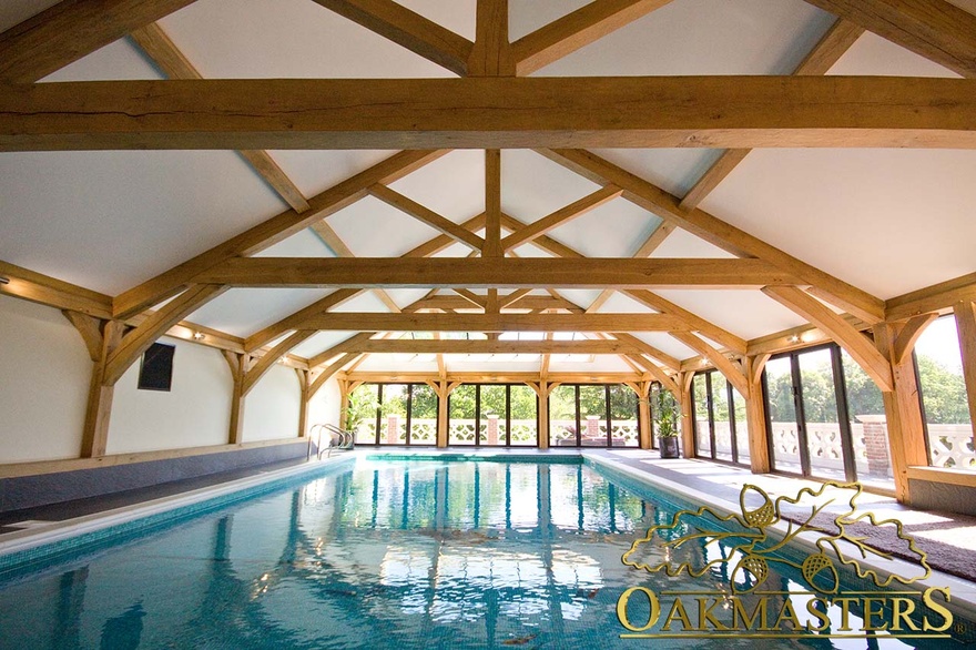 Multiple exposed raised king tie trusses support vaulted roof in pool house