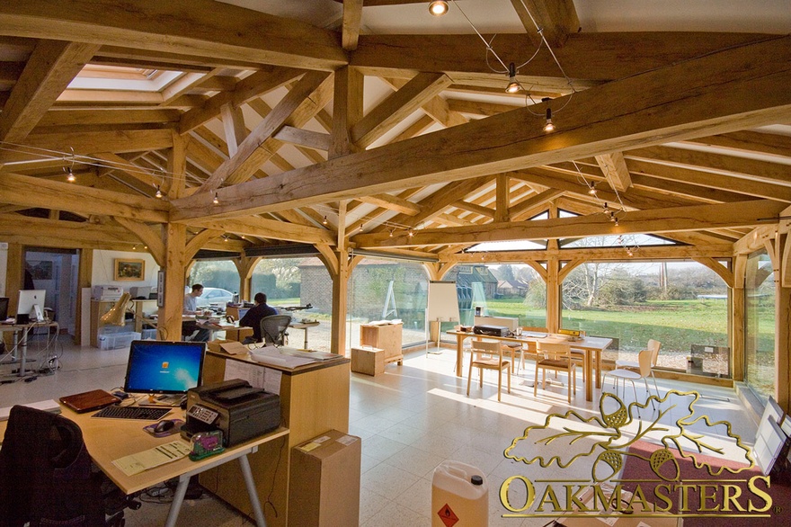Low pitch roof in office given height with vaulted ceiling and exposed oak truss and beams