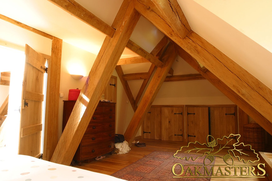 Irregular shape of these oak trusses gives this loft bedroom an interesting dimension