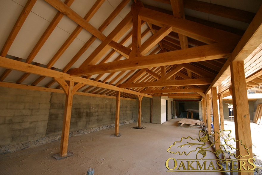 Oak columns support row of king post trusses in extension under construction