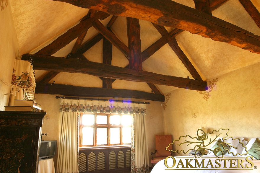 Traditional king post truss and open ceiling in small bedroom space