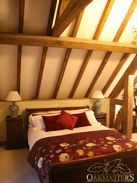 Detail of exposed roof rafters above a bed