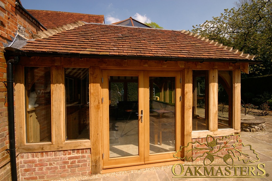 Oak-frame glazed doors and glass lantern orangery roof on brick manor house
