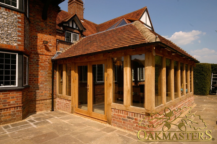 Oak-frame glazed patio doors of orangery on listed brick manor house