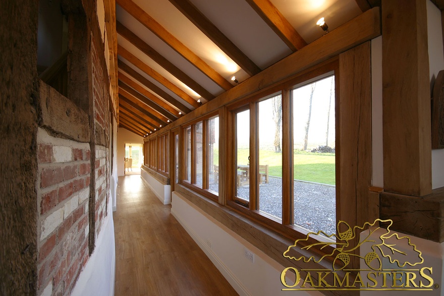 Glazed verandah with oakframe glazing and exposed decorative rafters in listed house