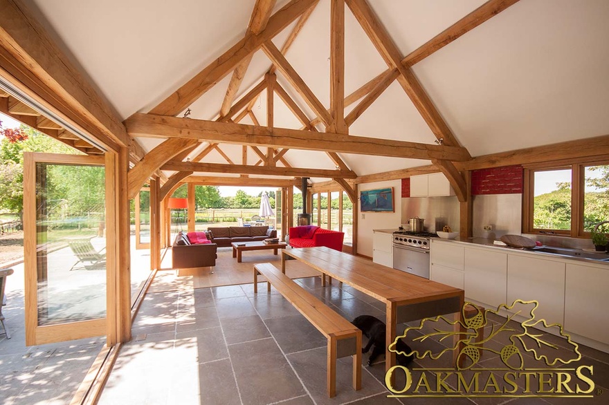 Modern kitchen with oak frame exposed truss open ceiling and oak frame glazing