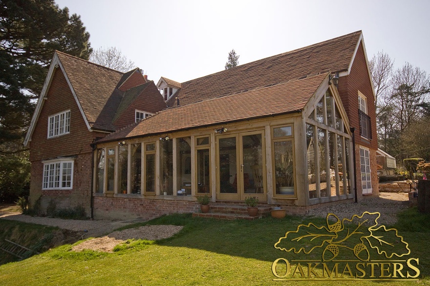 Exterior of multilevel glazed garden room with oak frame and glazed gable