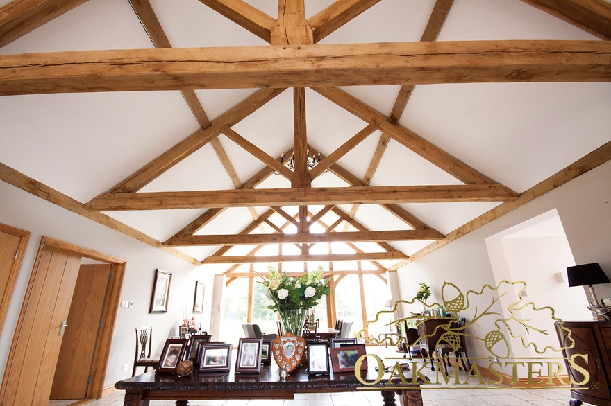 A sieries of oak trusses in  a long dining room in a beautifully designed modern oak extension