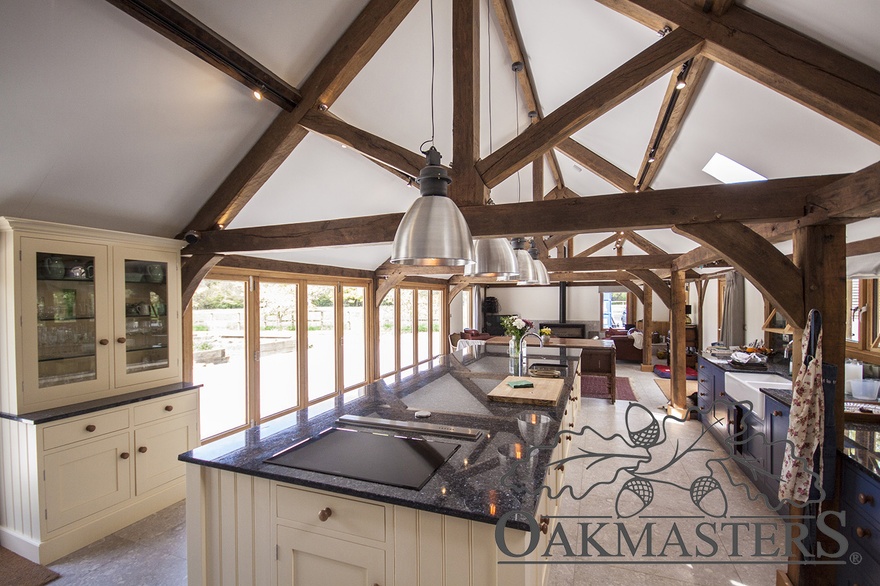 A long kitchen diner space with an oak open vaulted ceiling featuring king post trusses