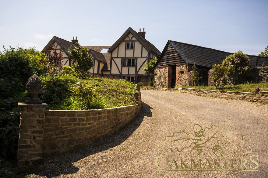 Stunning driveway framed with shrubs leads to the oak framed manor house