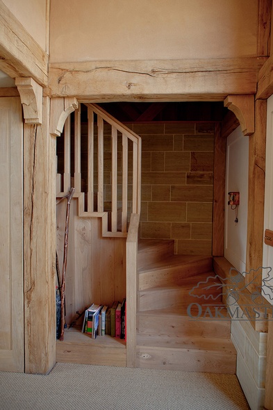 Structural oak frame with oak posts and small oak brackets creates a lovely entrance to the staircase in this oak barn