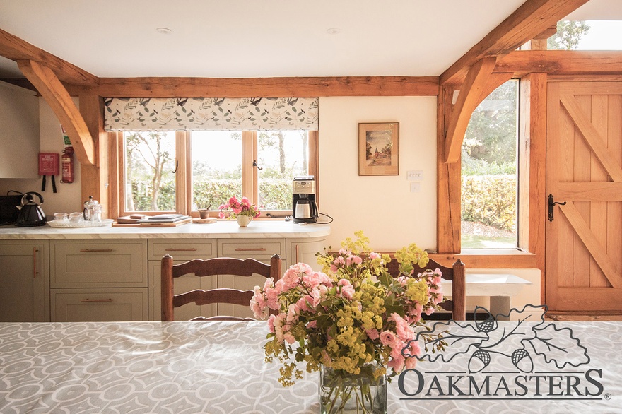 Open plan kitchen and dining area are framed with oak beams and posts.