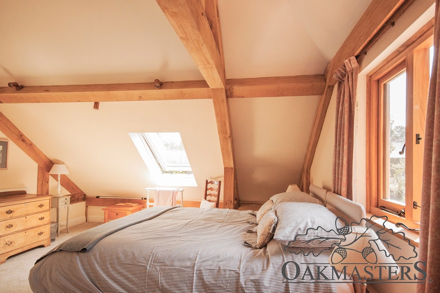Vaulted ceiling with an oak truss create a lovely traditional feel in this bedroom.