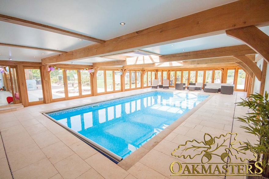 Oak swimming pool building has a combination of glazing and bifold doors on three sides