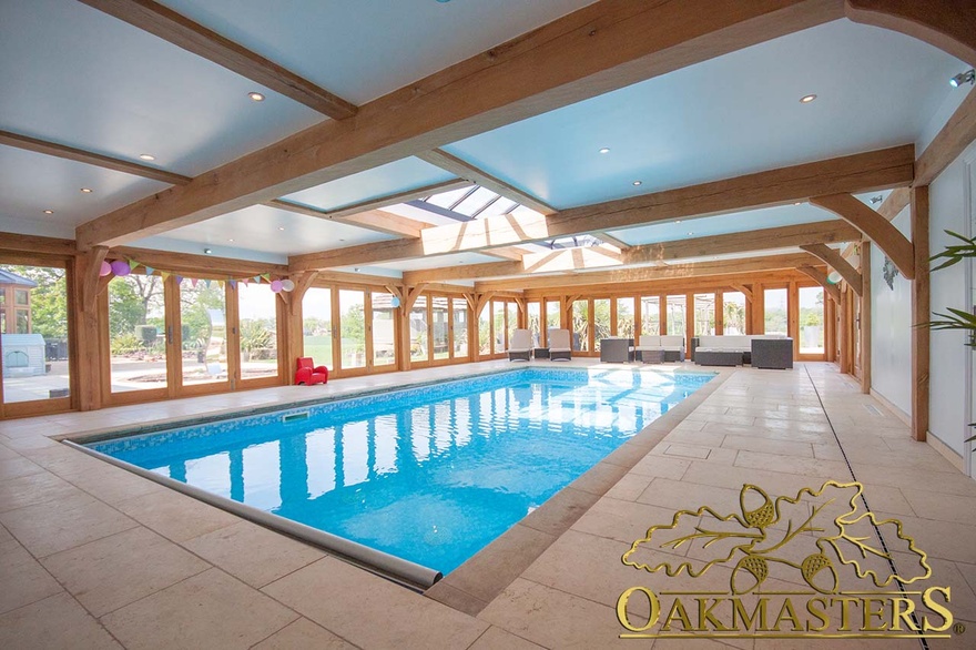 Light shines through the roof lanterns of this oak framed pool house