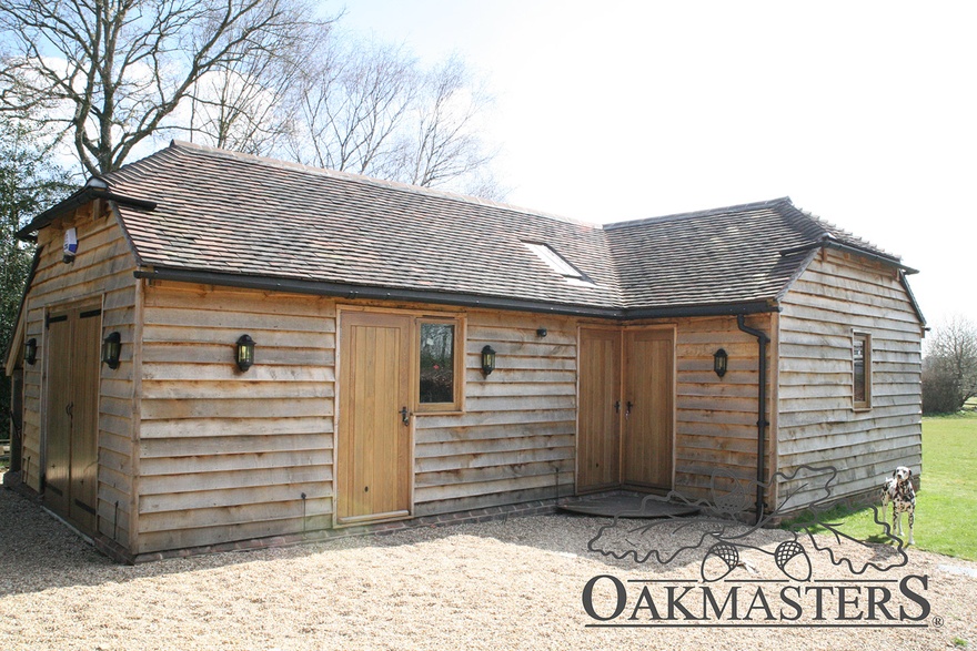 The oak garage and garden room complex is clad in featheredge cladding