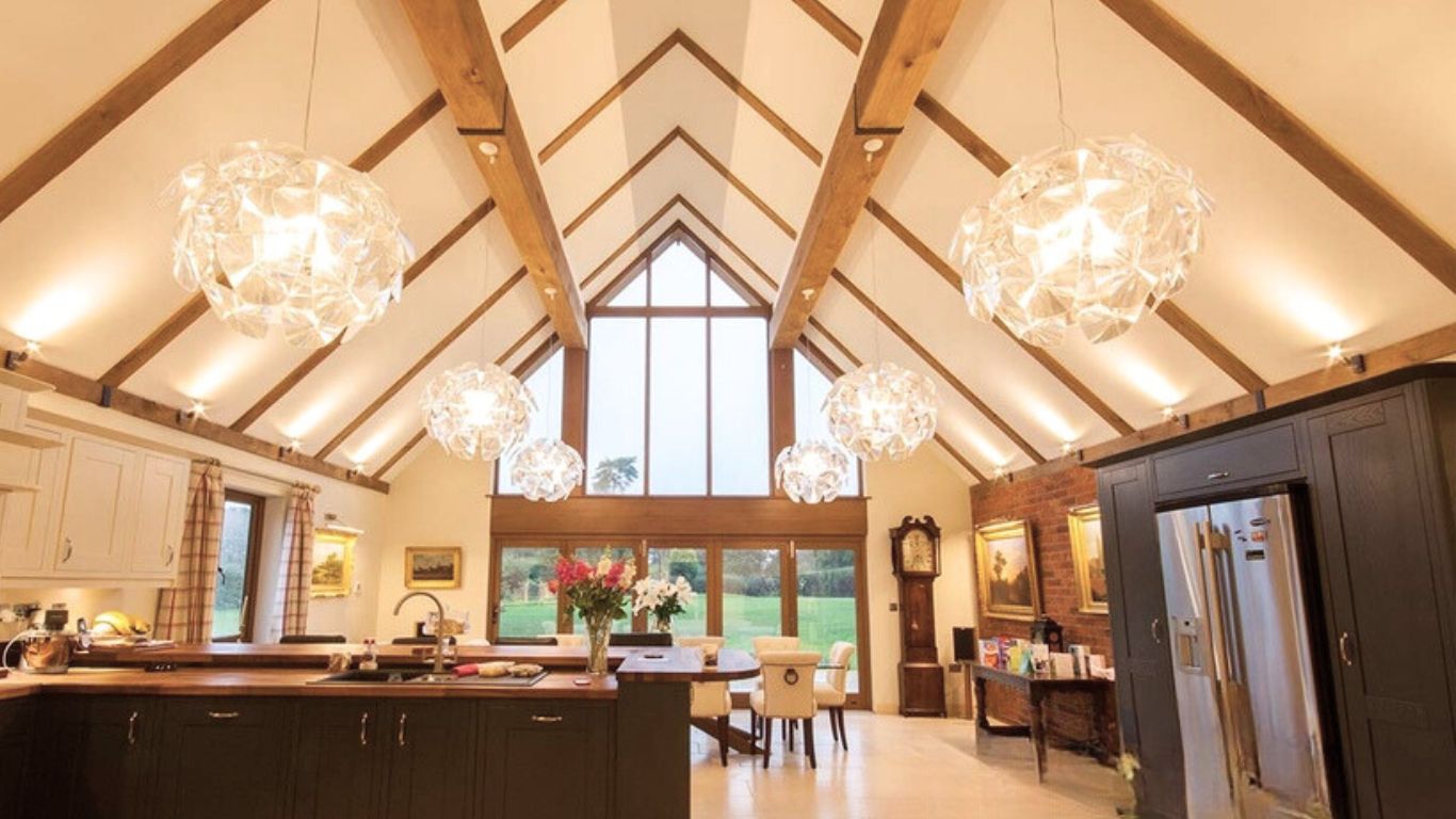 Spacious kitchen featuring exposed three-sided oak beam covers across the ceiling, concealing RSJs for a seamless and stylish look.