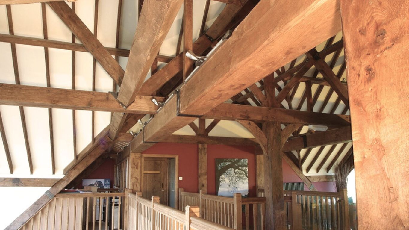 Four-sided oak beam cover elegantly concealing pipework and lintels in a home, enhancing its character and charm.