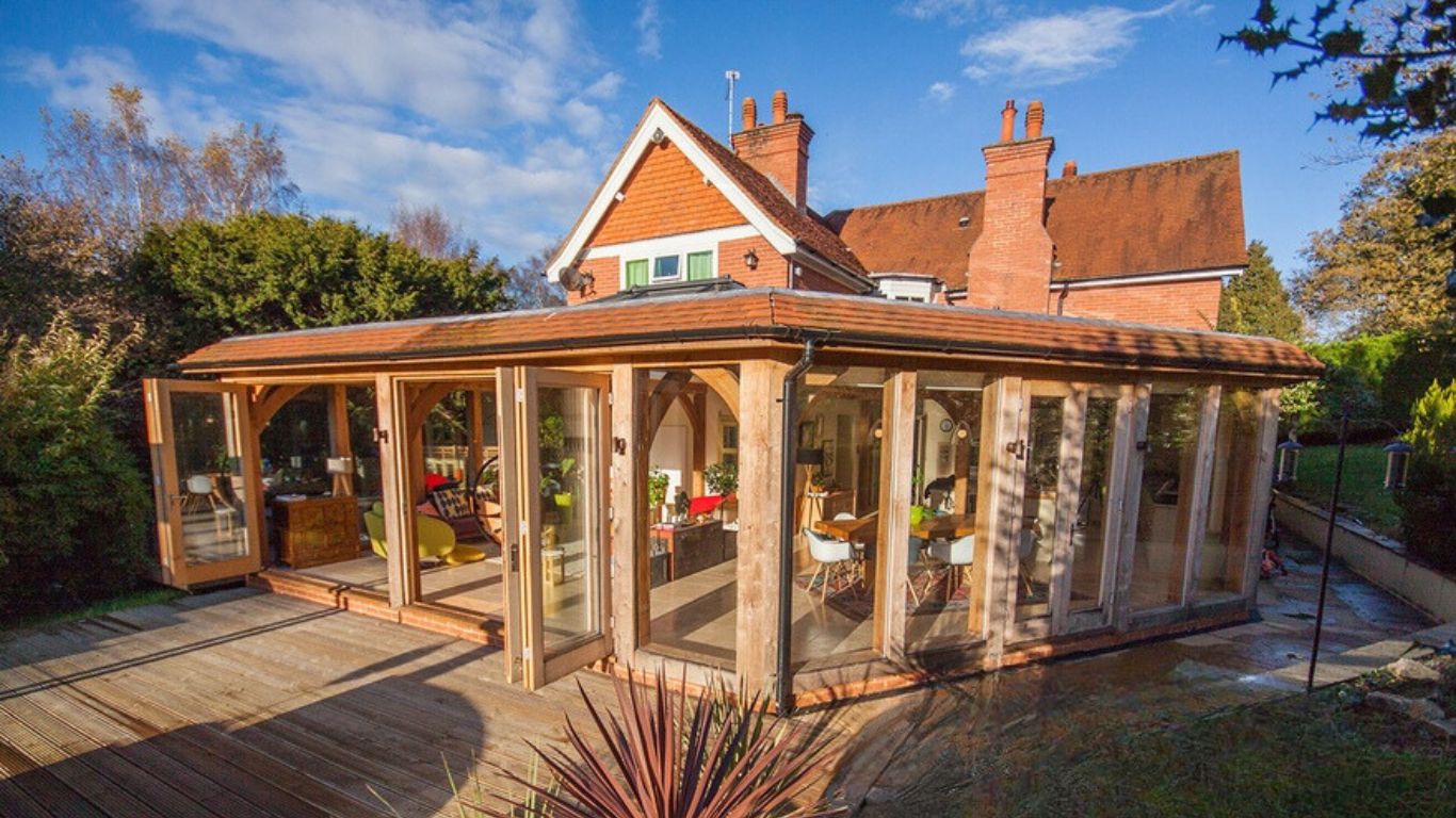 A modern glazed oak framed orangery integrated into a home extension, adding natural light to the living space.