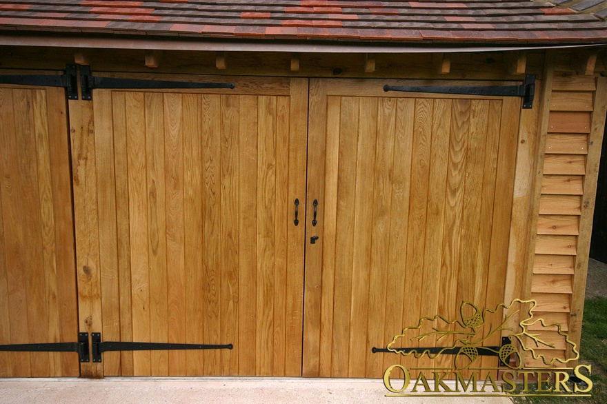 Solid oak double garage door detail with wrought iron hinges