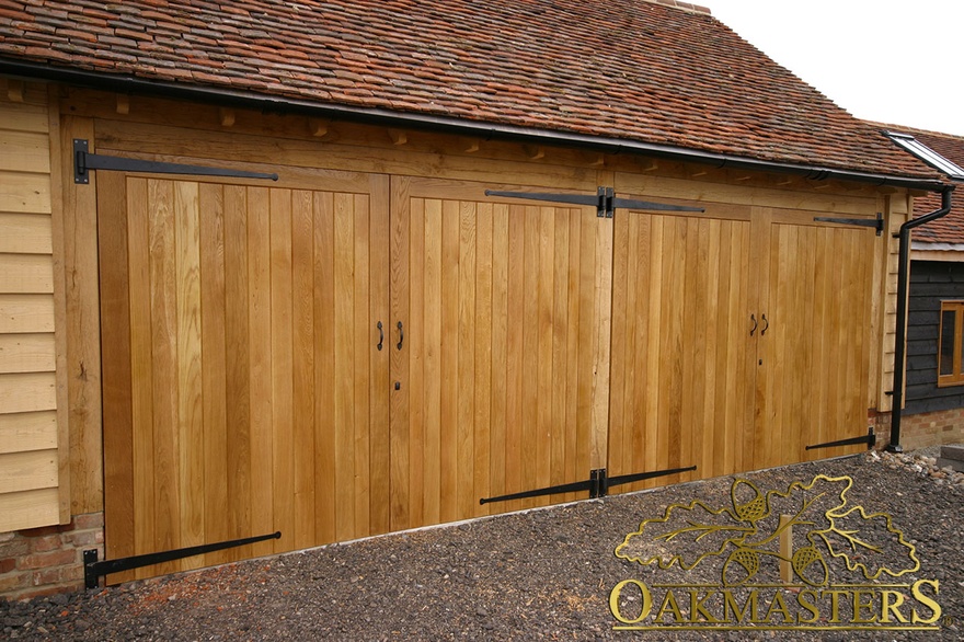 Detail of two double oak garage doors with wrought iron hinges