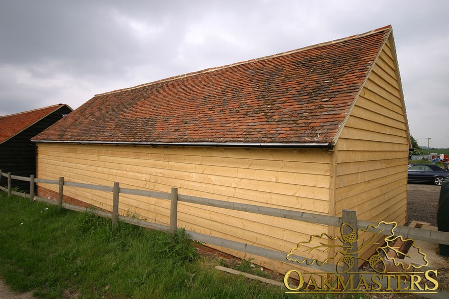 Rear view of a four bay oak clad garage with tiled roof