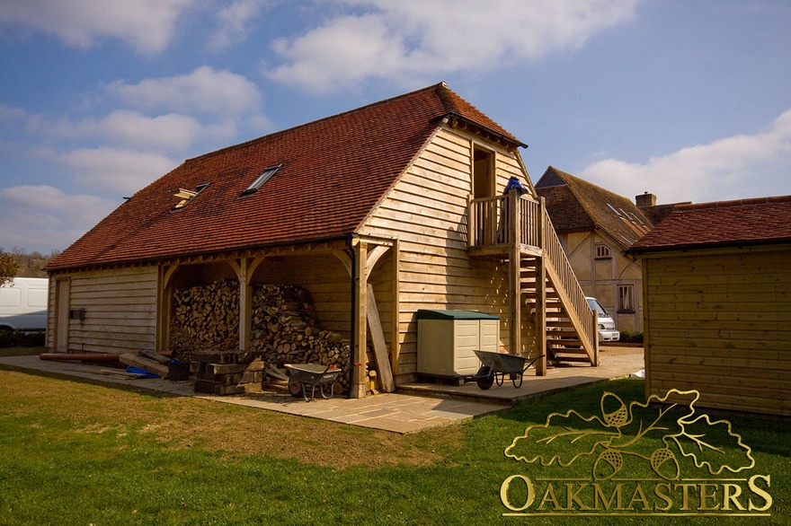 Rear view of oak framed garage with open log store