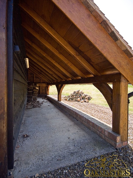 Detail of open log store under an oak cat slide roof