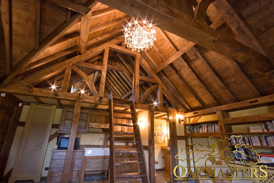 Exposed oak truss forms the entrance into the loft room in an oak framed garage